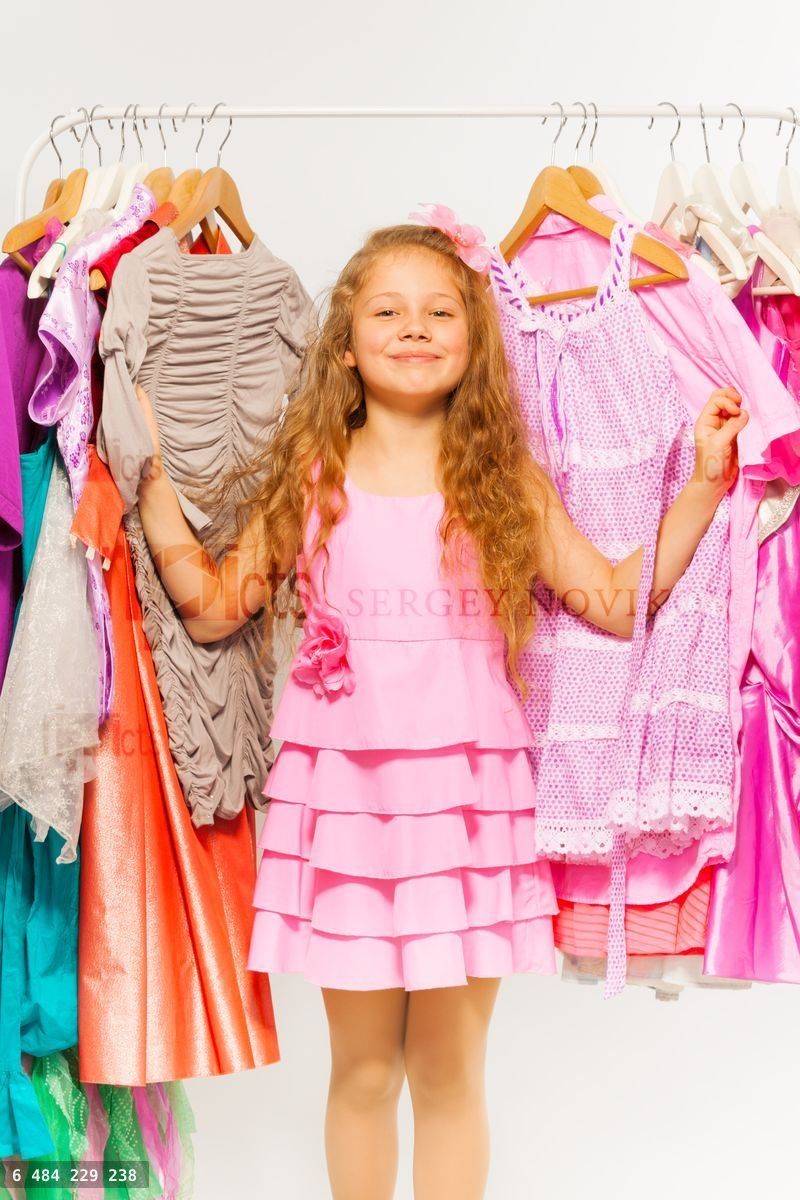 Girl during shopping standing between hangers