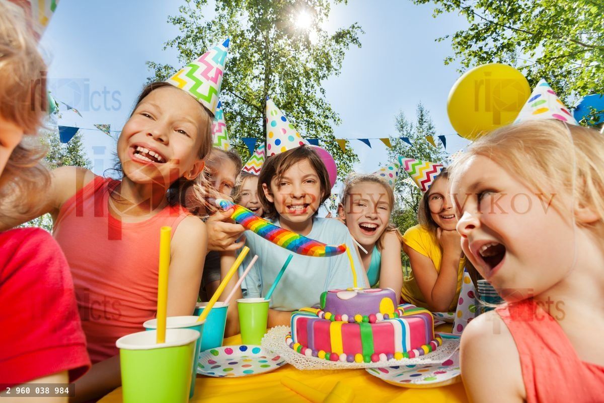 Group of funny kids having fun around party cake