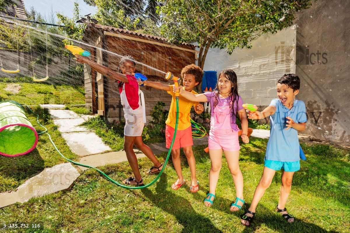 Fun water gun game with group of friends in garden