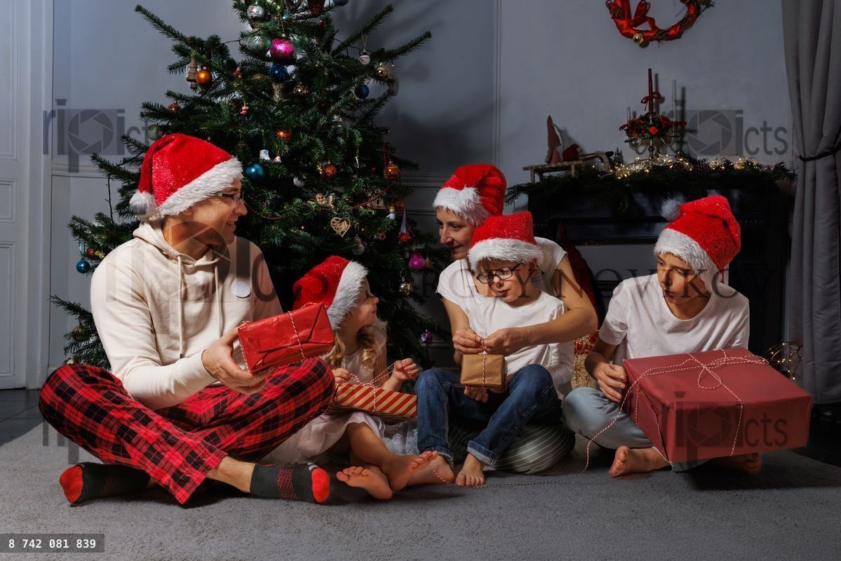 Celebrating Christmas together, family unwraps presents happily