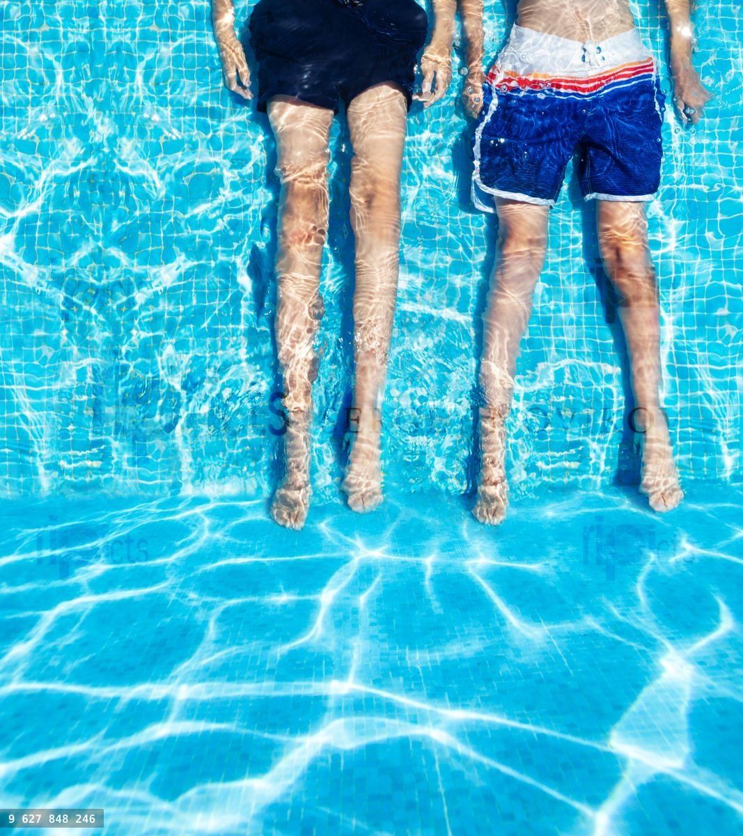 Children lay submerged in the shallow pool water