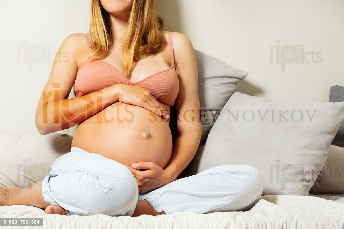 Woman touch big pregnant belly close up image