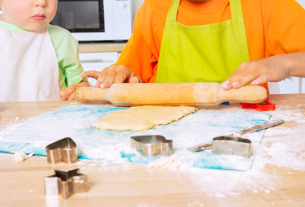 Close up of children's hands roll dough with ram