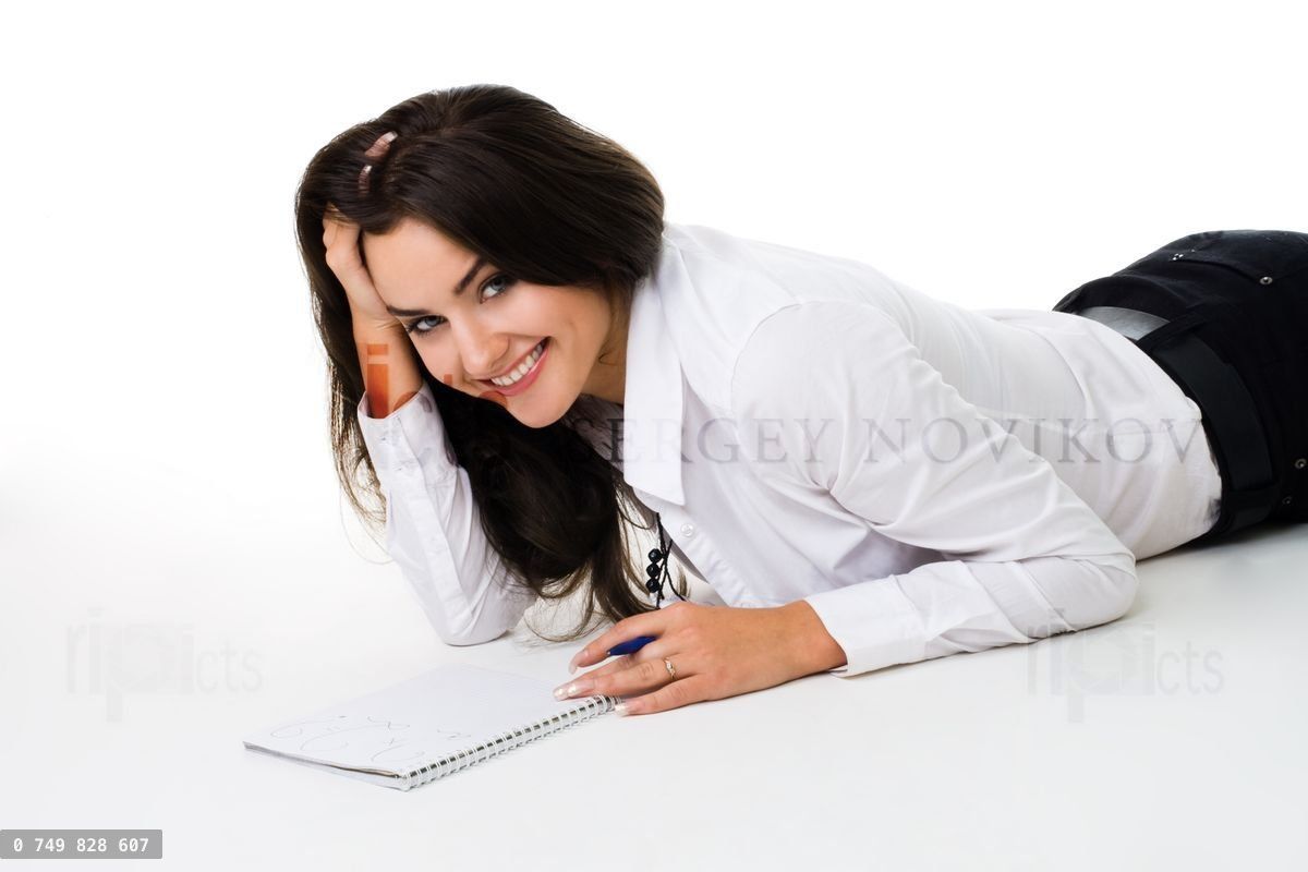 Woman laying on the floor with note book smiling and laughing