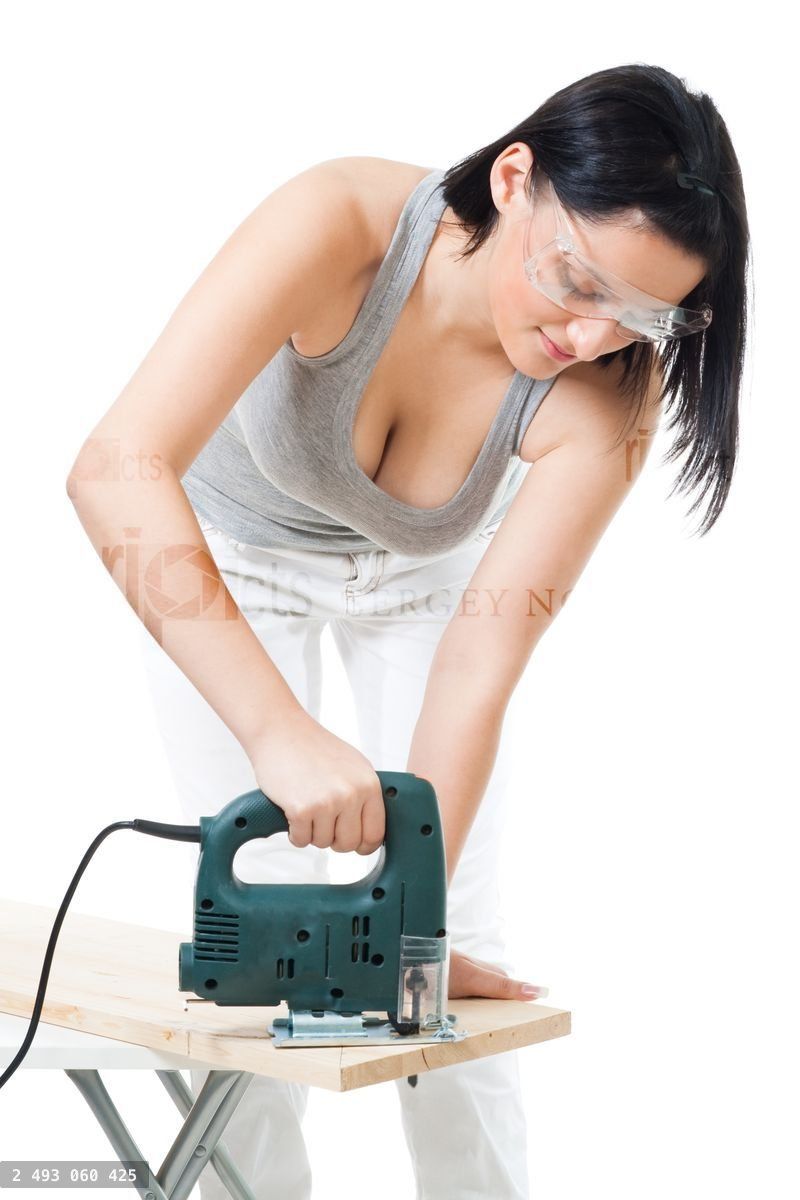 Woman cut wood plank with electric saw