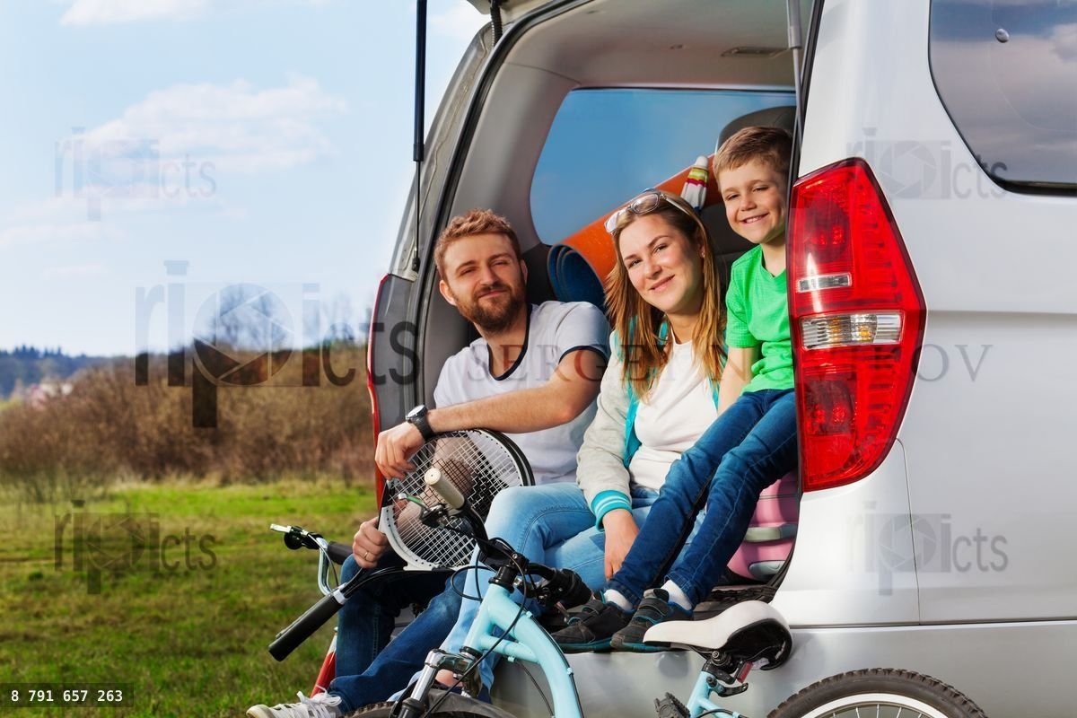 Happy sporty family sitting in the car boot