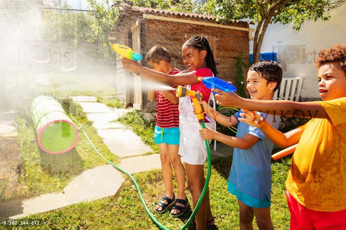 Fun kids with water guns fighting in the garden