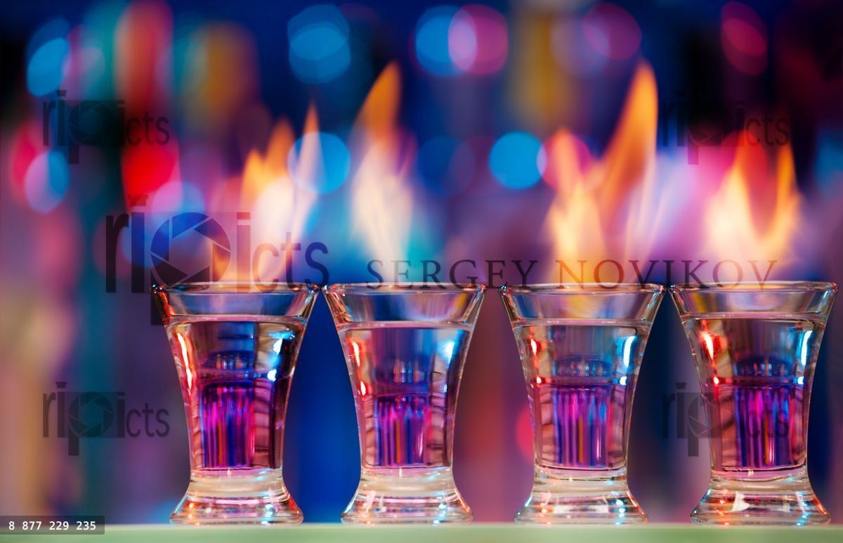 Four hot shot glasses on a bar counter