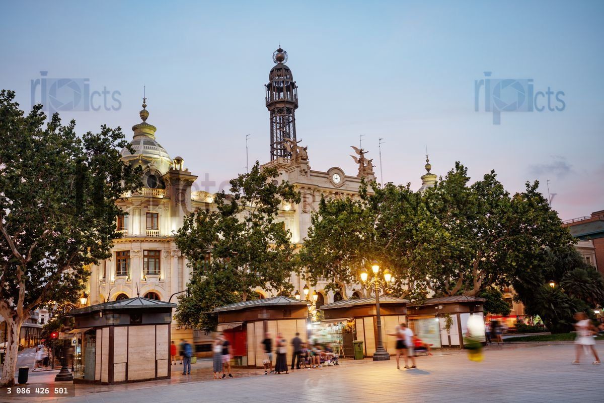 Communication Palace of Valencia shines at dusk, square in front