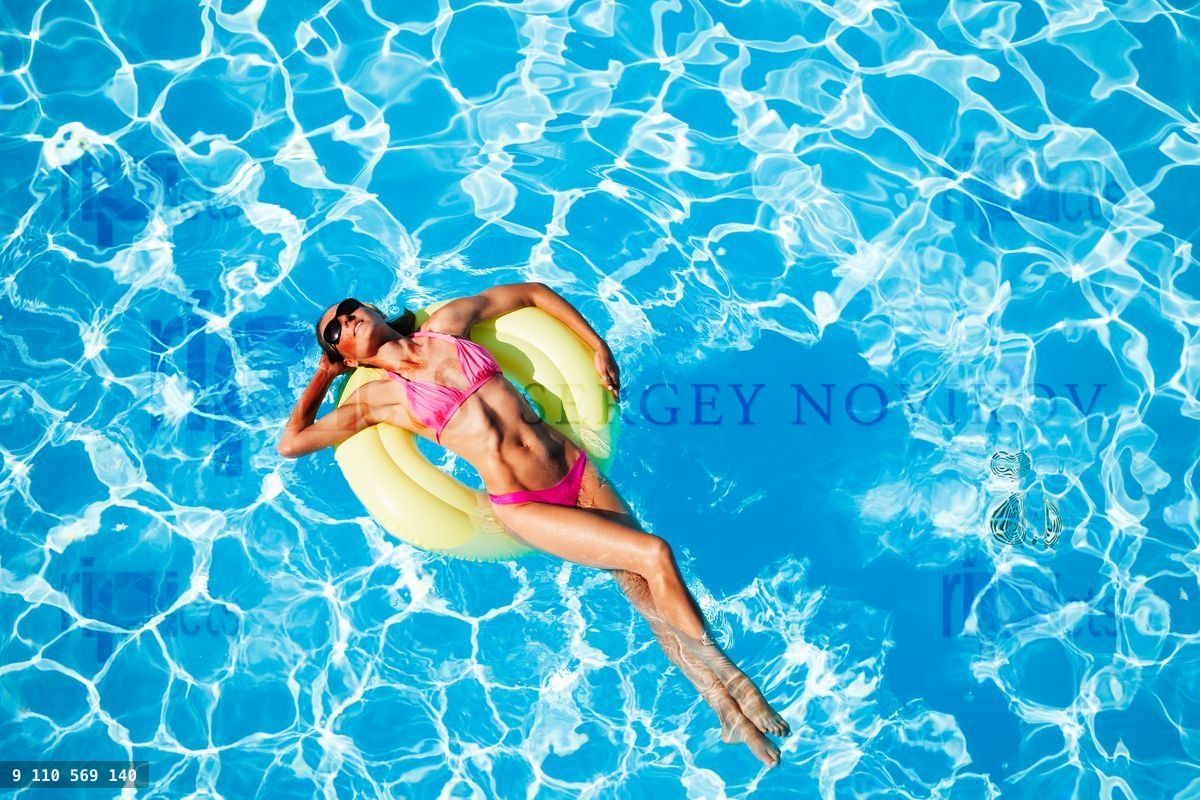 Woman relaxing on rubber ring in the swimming pool