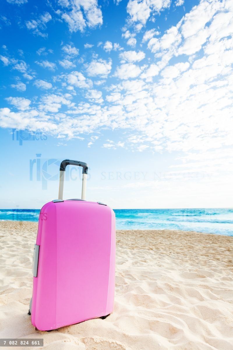 Roze koffer op het strand