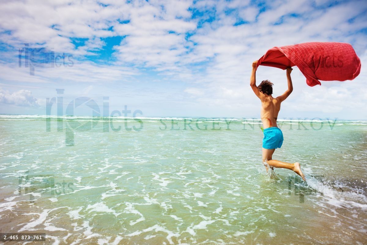 Dynamic concept child run on beach with towel fly