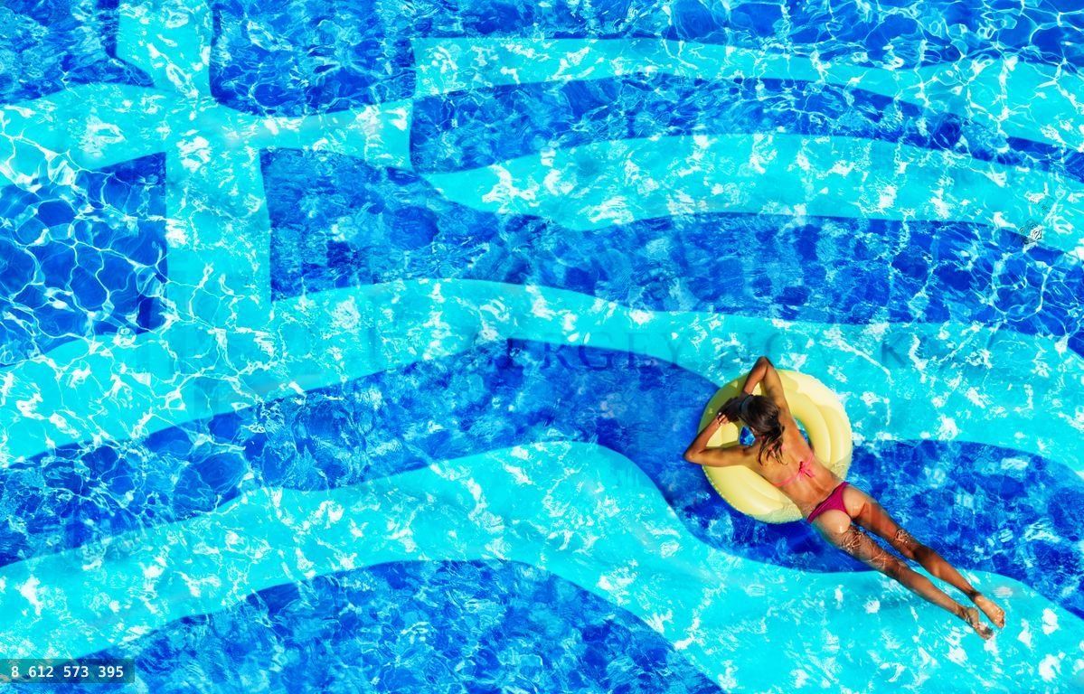 Woman swimming in the pool with Greek flag below