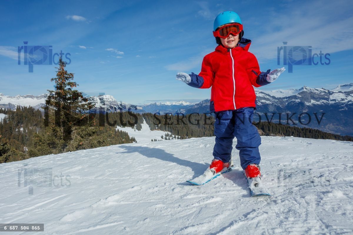 Young skier boy in bright gear on a beautiful snowy mountain