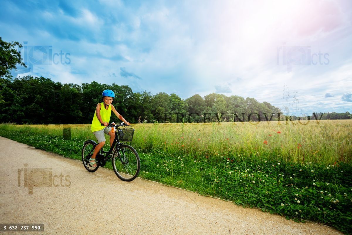 Young boy ride a bicycle in the park near field