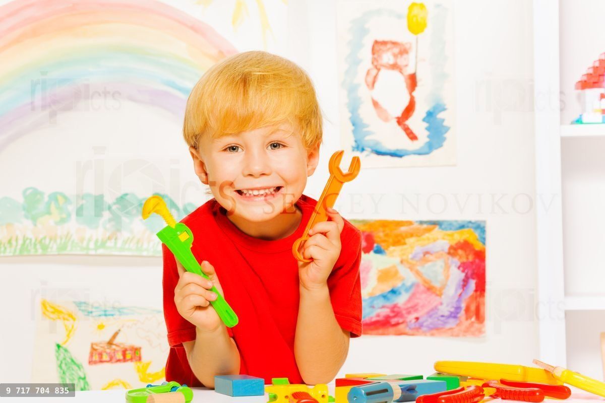 Handsome blond boy with wrench in classroom