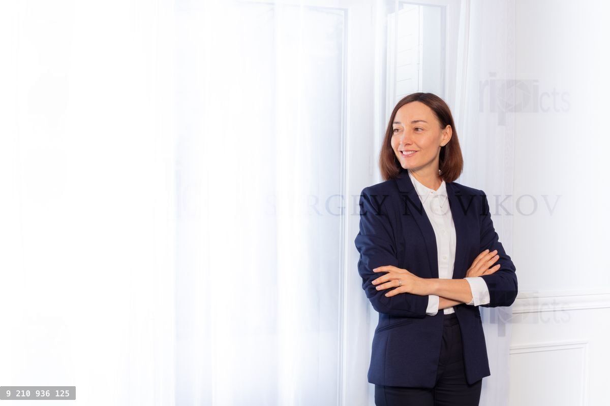 Woman in business suit standing with arms folded