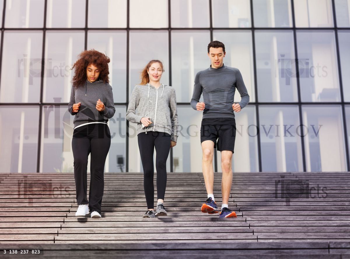 Young athletes going down outdoors on city stairs