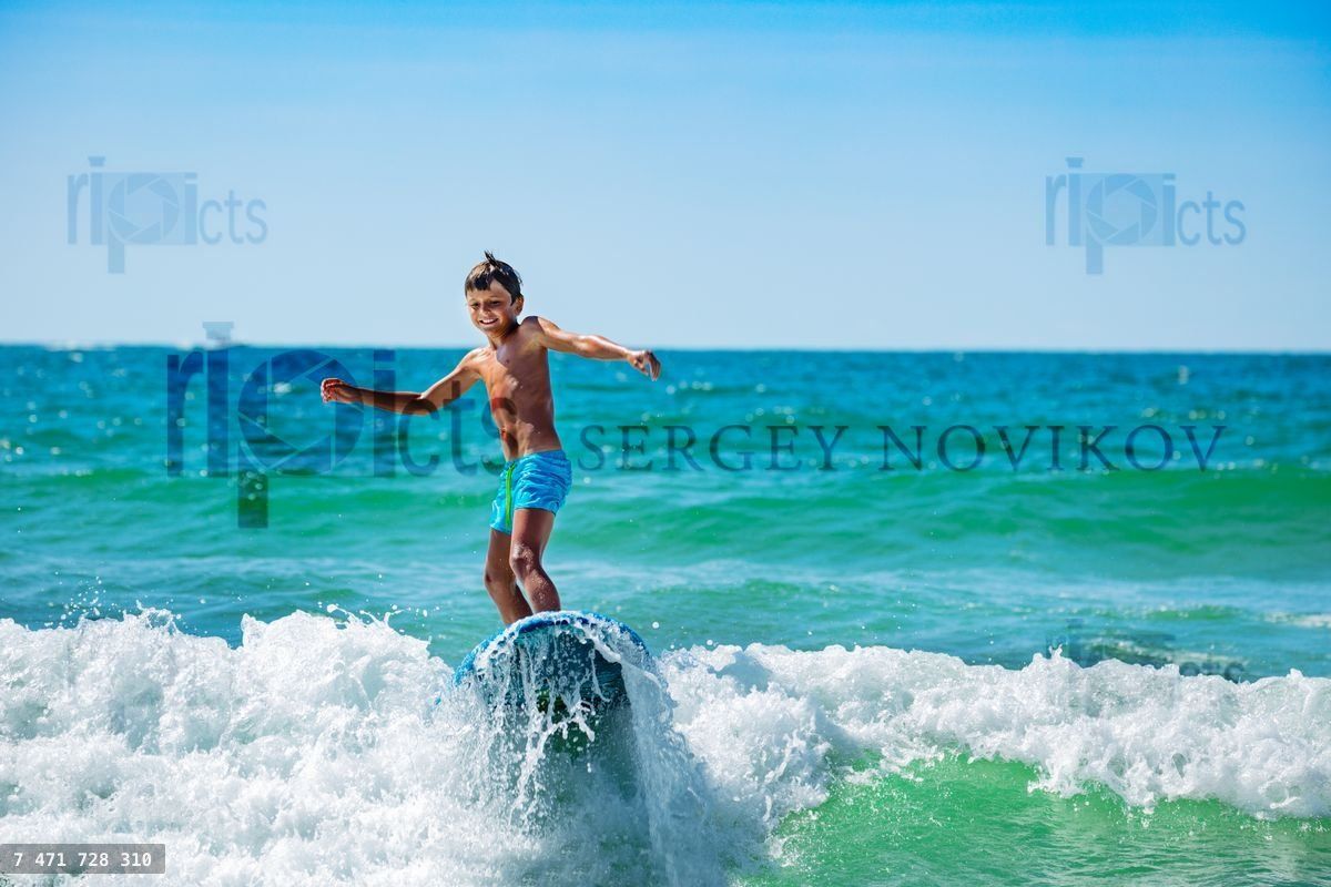Boy action photo ride surfboard on top of a wave