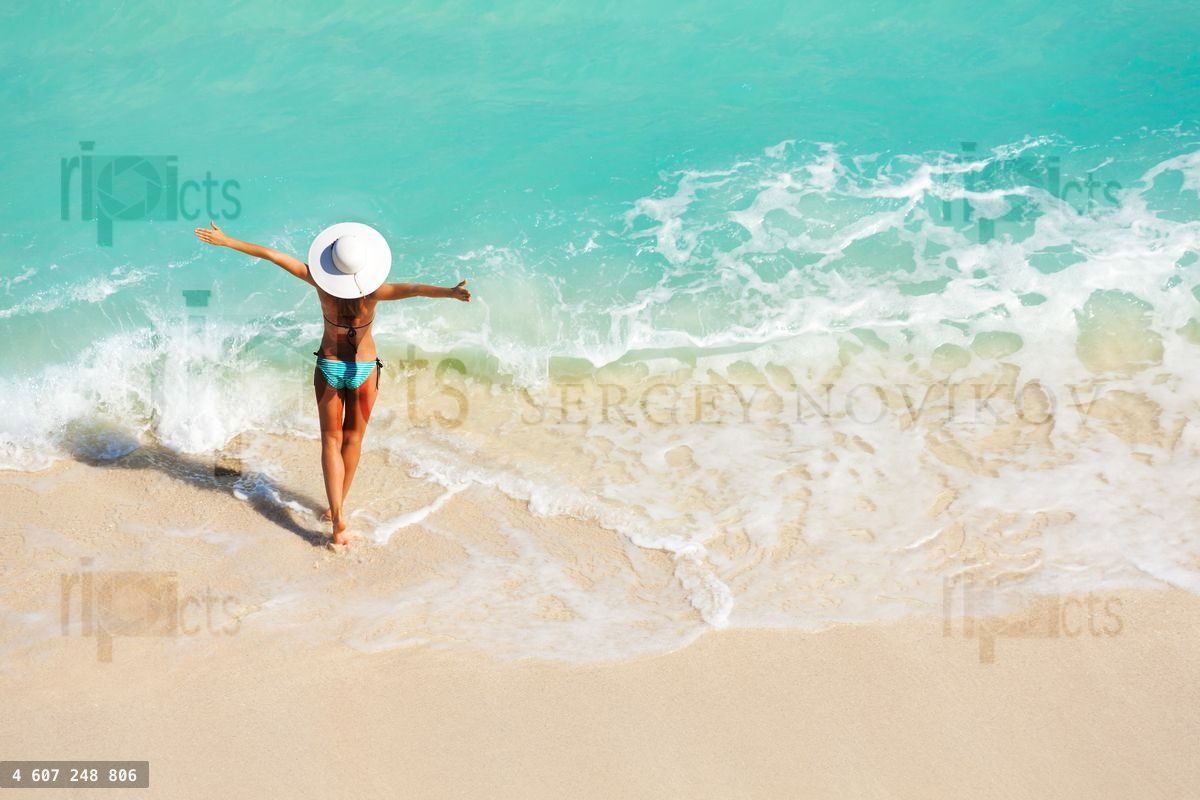 Young woman with arms apart on sand beach