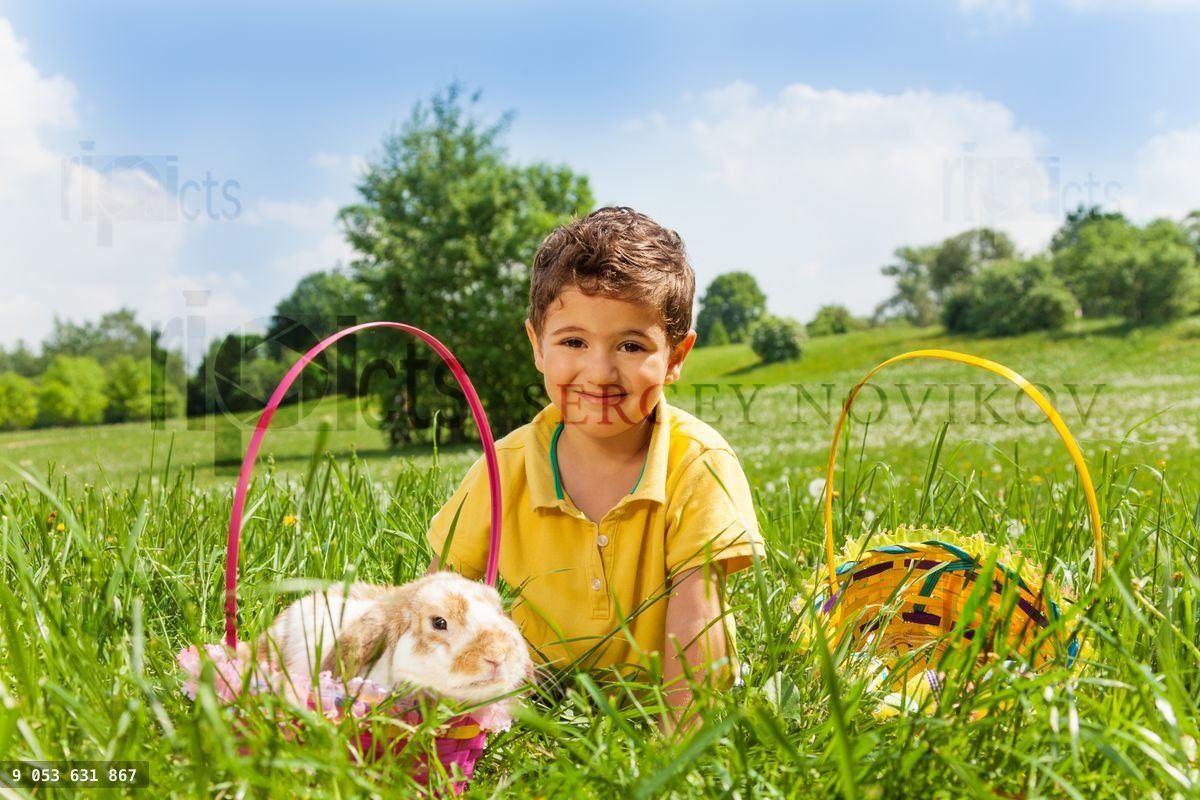 Boy with rabbit and two baskets in the park