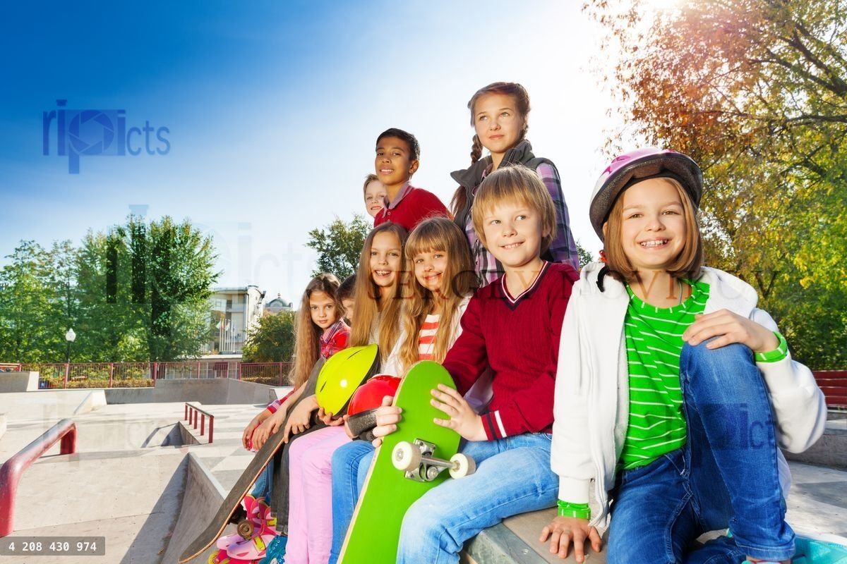 Beaucoup d'enfants avec des skateboards et des casques assis