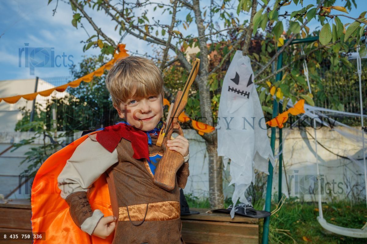 Halloween fun as child poses with cape and festive ghost decor