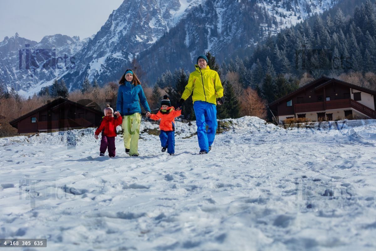 Family of four enjoys snowy mountain run and laugh hand in hand