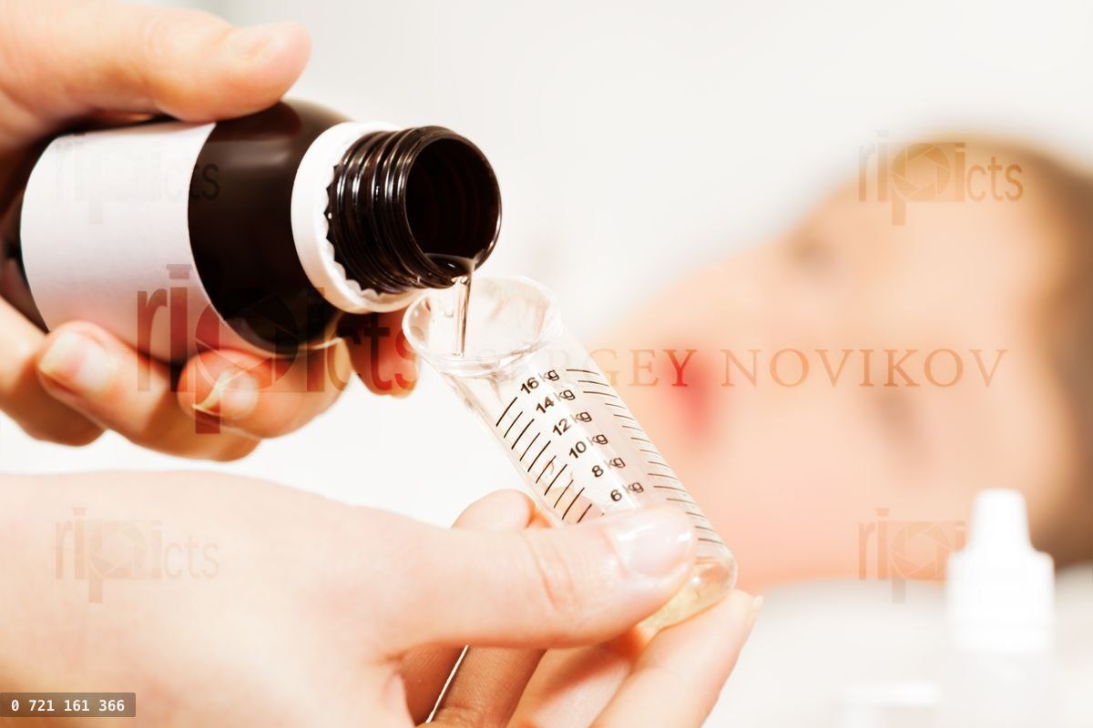 Woman's hands pouring medicinal product to spoon