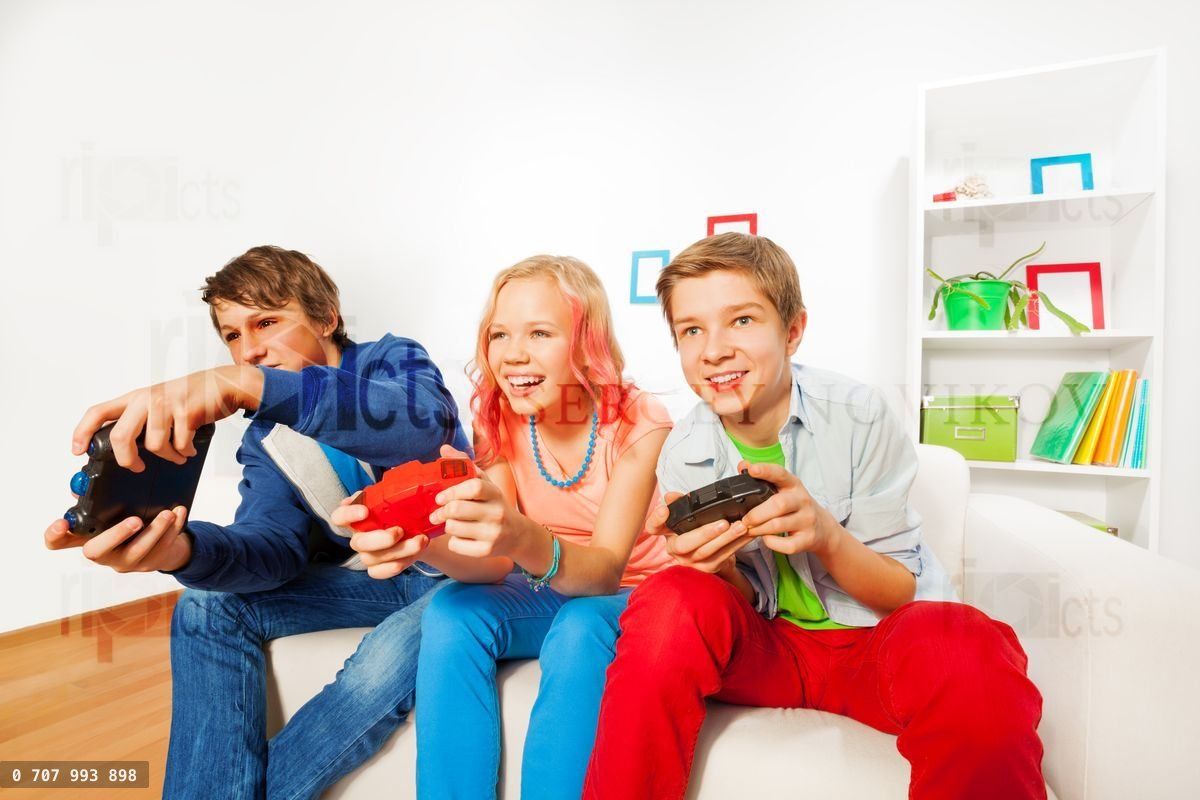 Girl and boys with joysticks playing game console