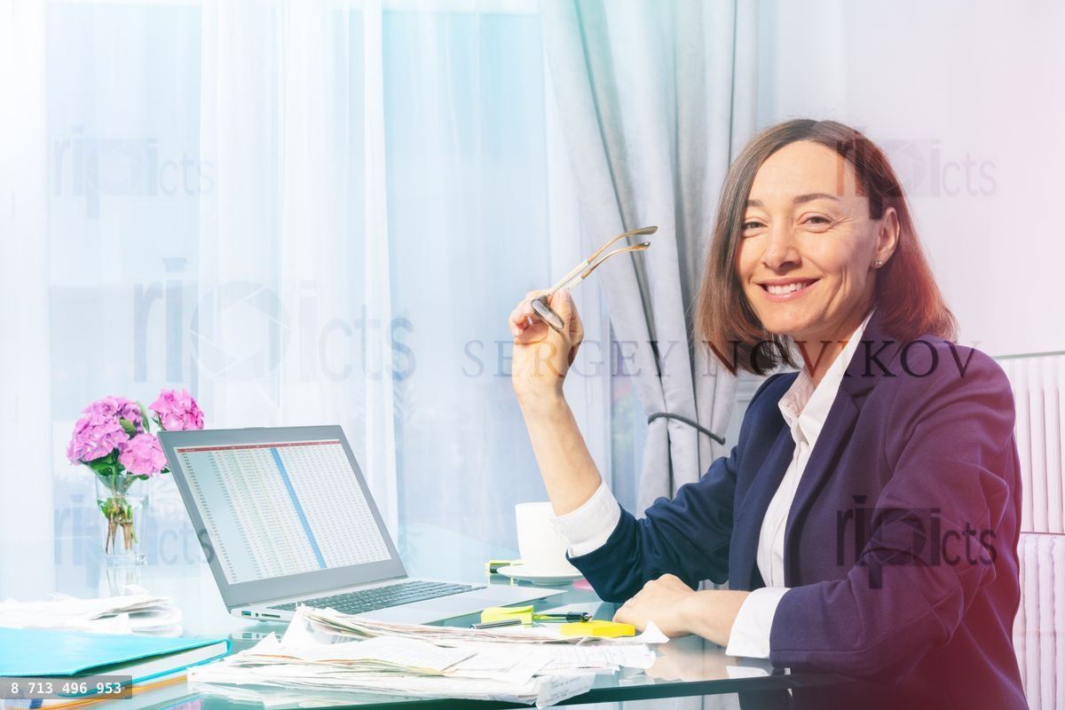 Woman working with papers and laptop in the office