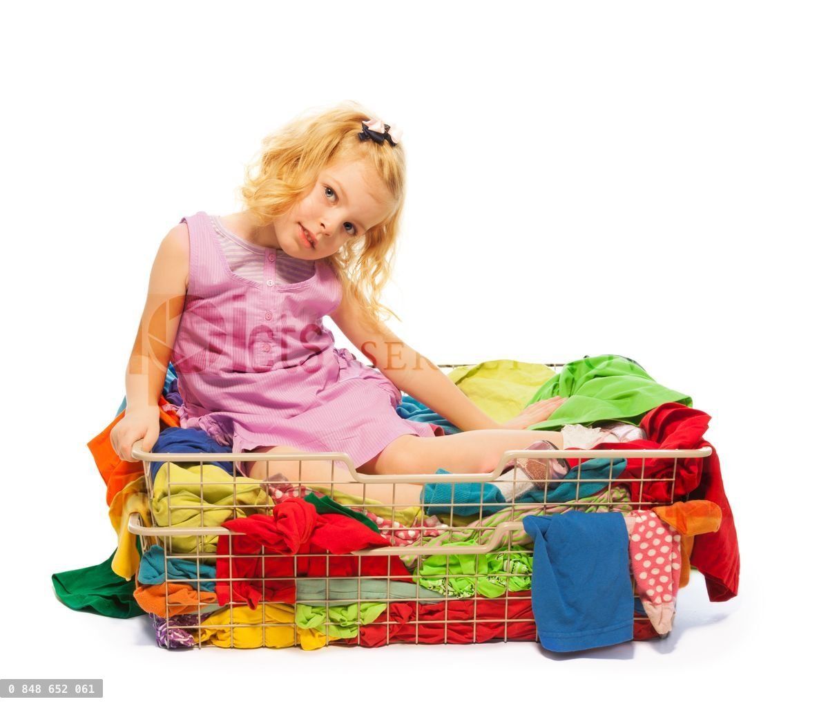 Blond girl sitting in the basket with clothes