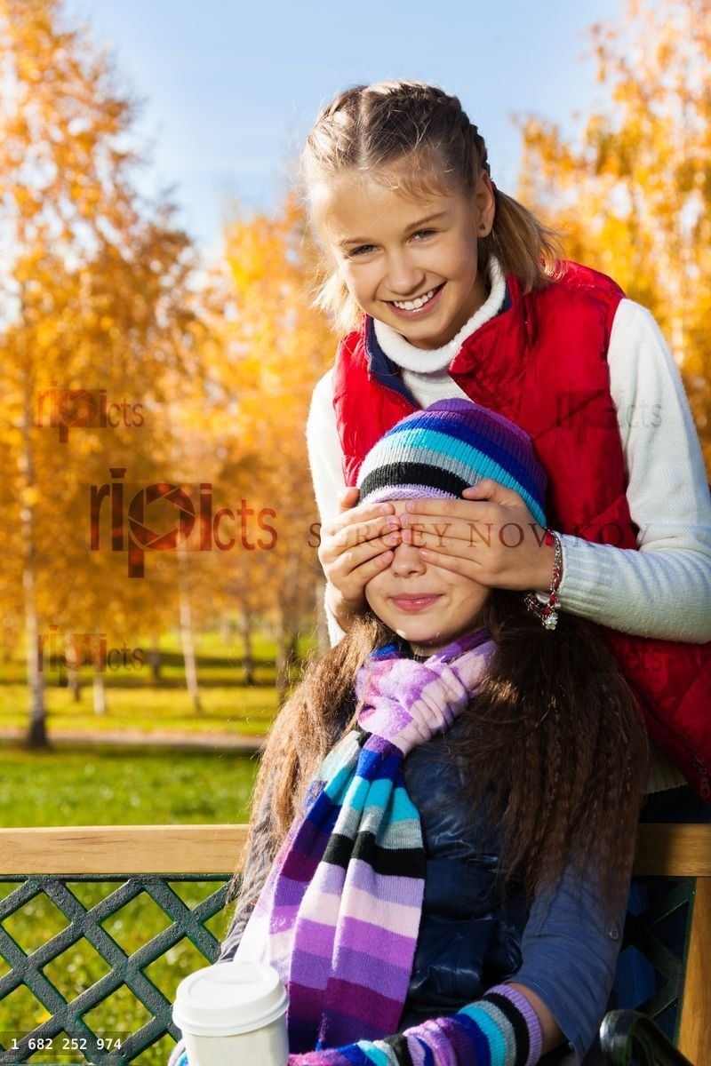 Girl covers friend face with palms and smile