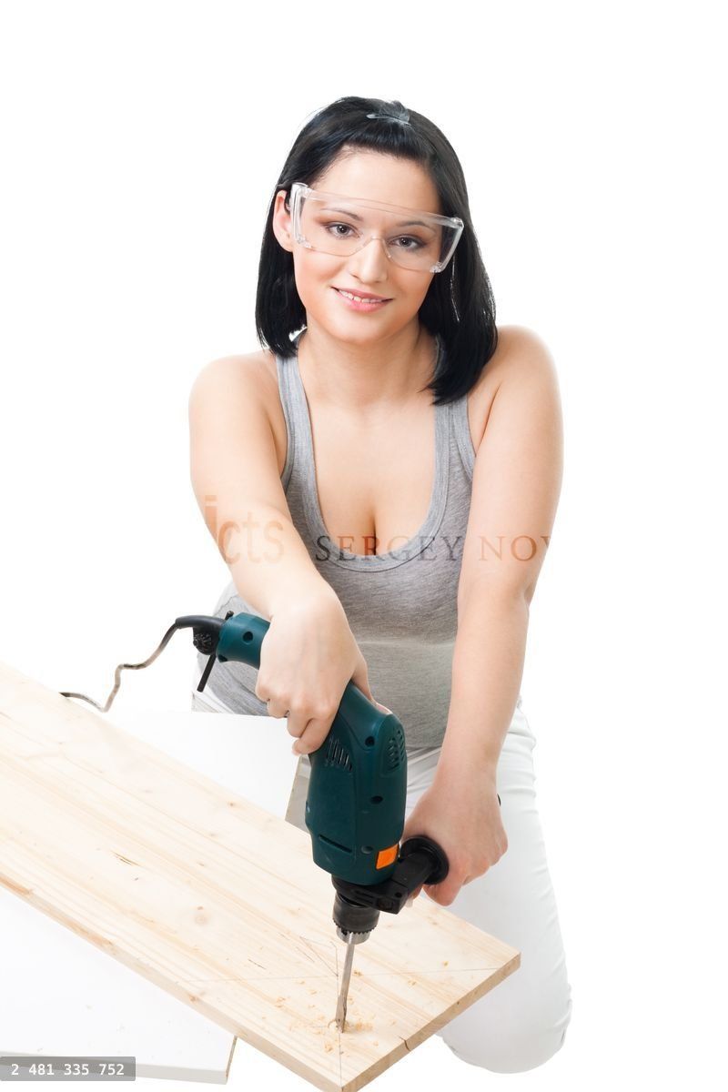 Woman drill hole in wood plank