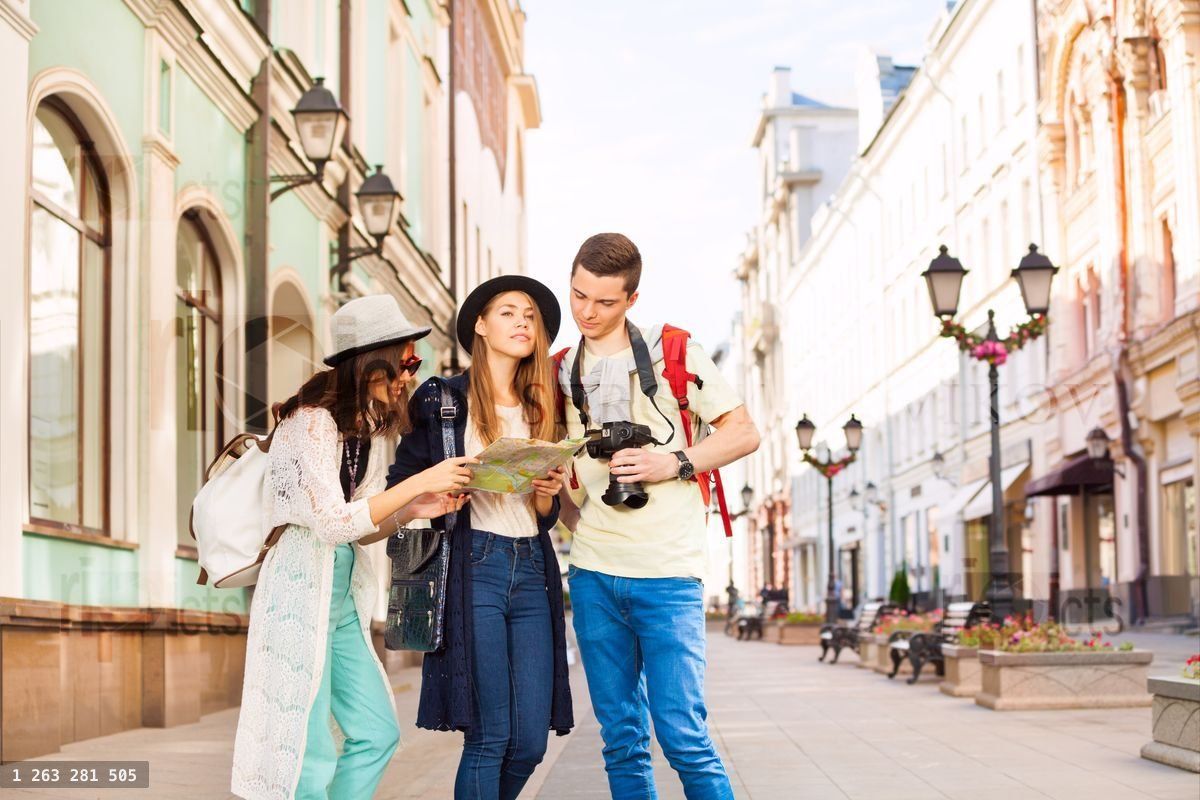 Filles et garçon tenant un appareil photo regardent une carte de ville