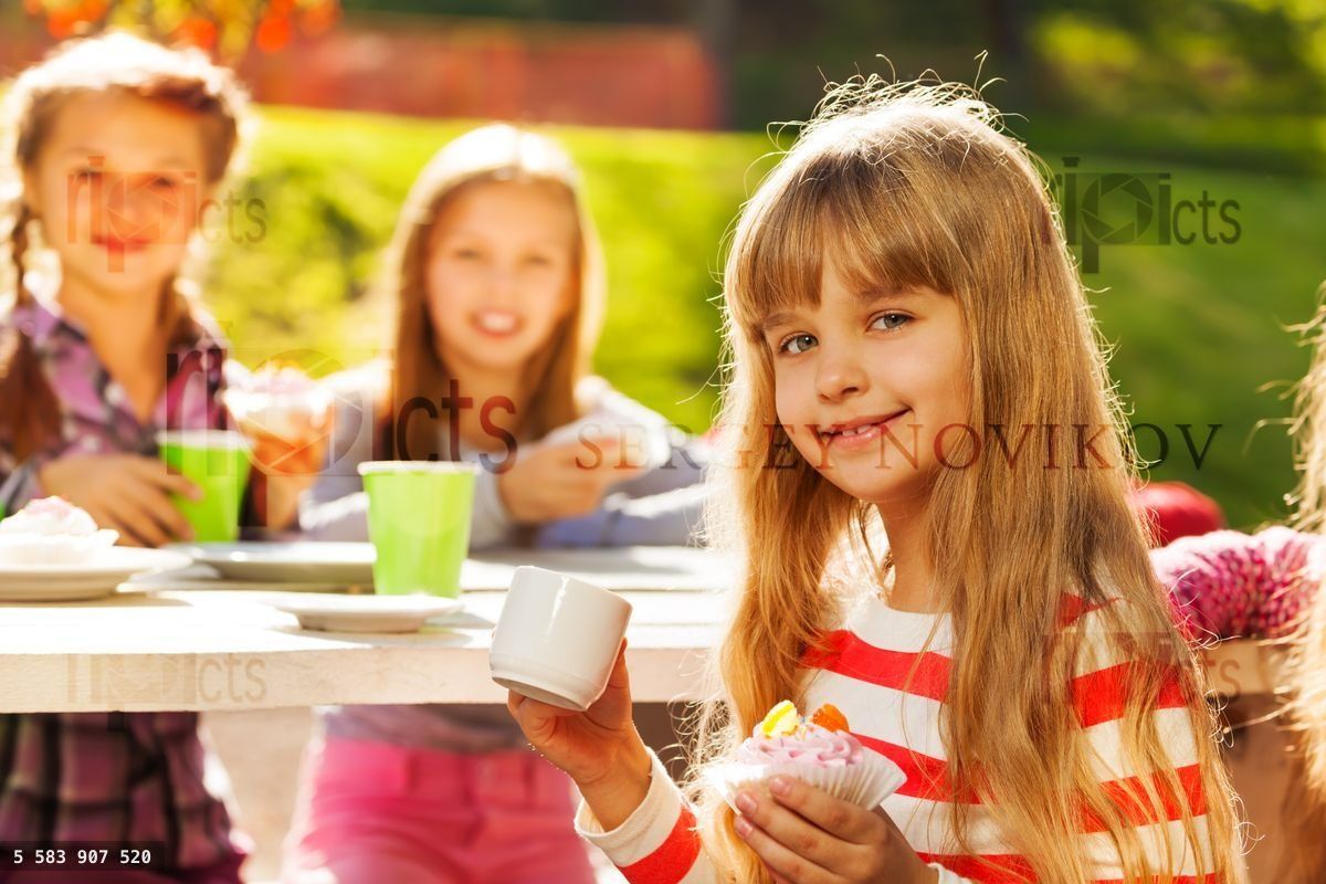 Close up view of blond girl holding cupcake