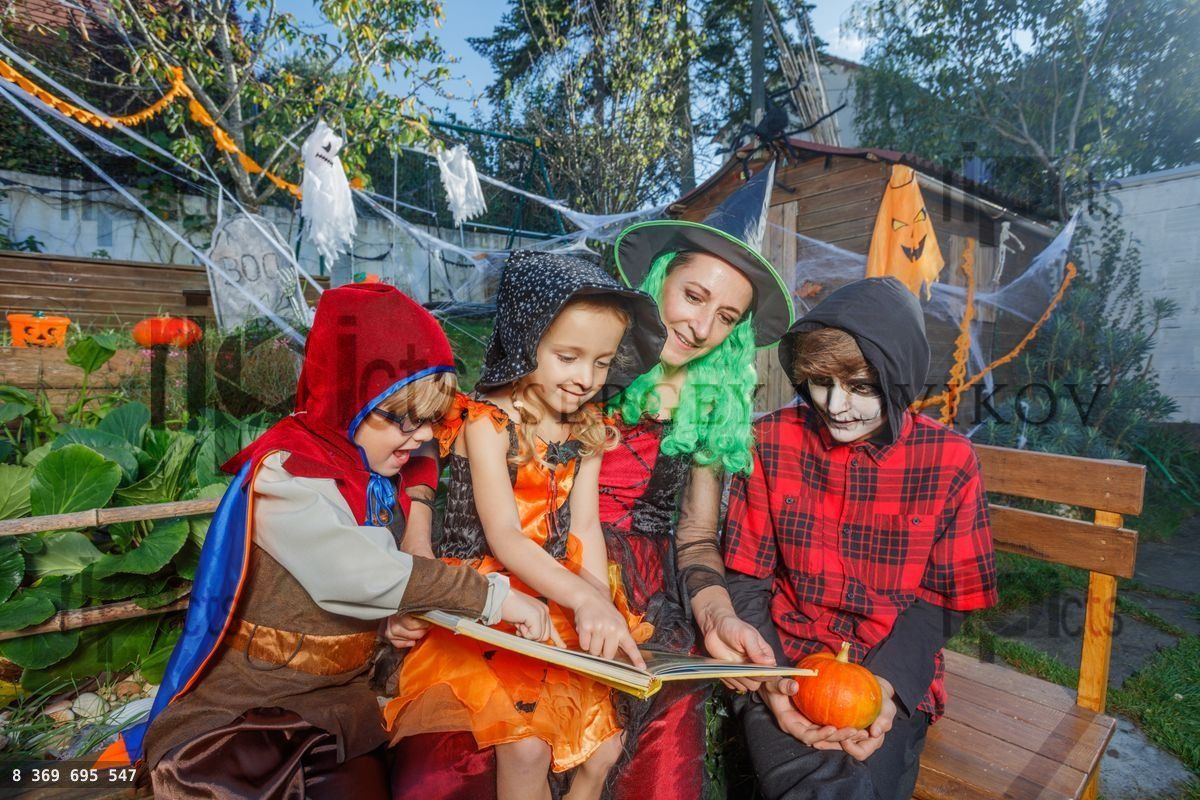 Family in costumes shares a Halloween story together outdoor
