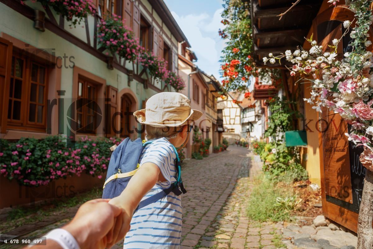 Young explorer enjoys a scenic alley stroll, hold in hand