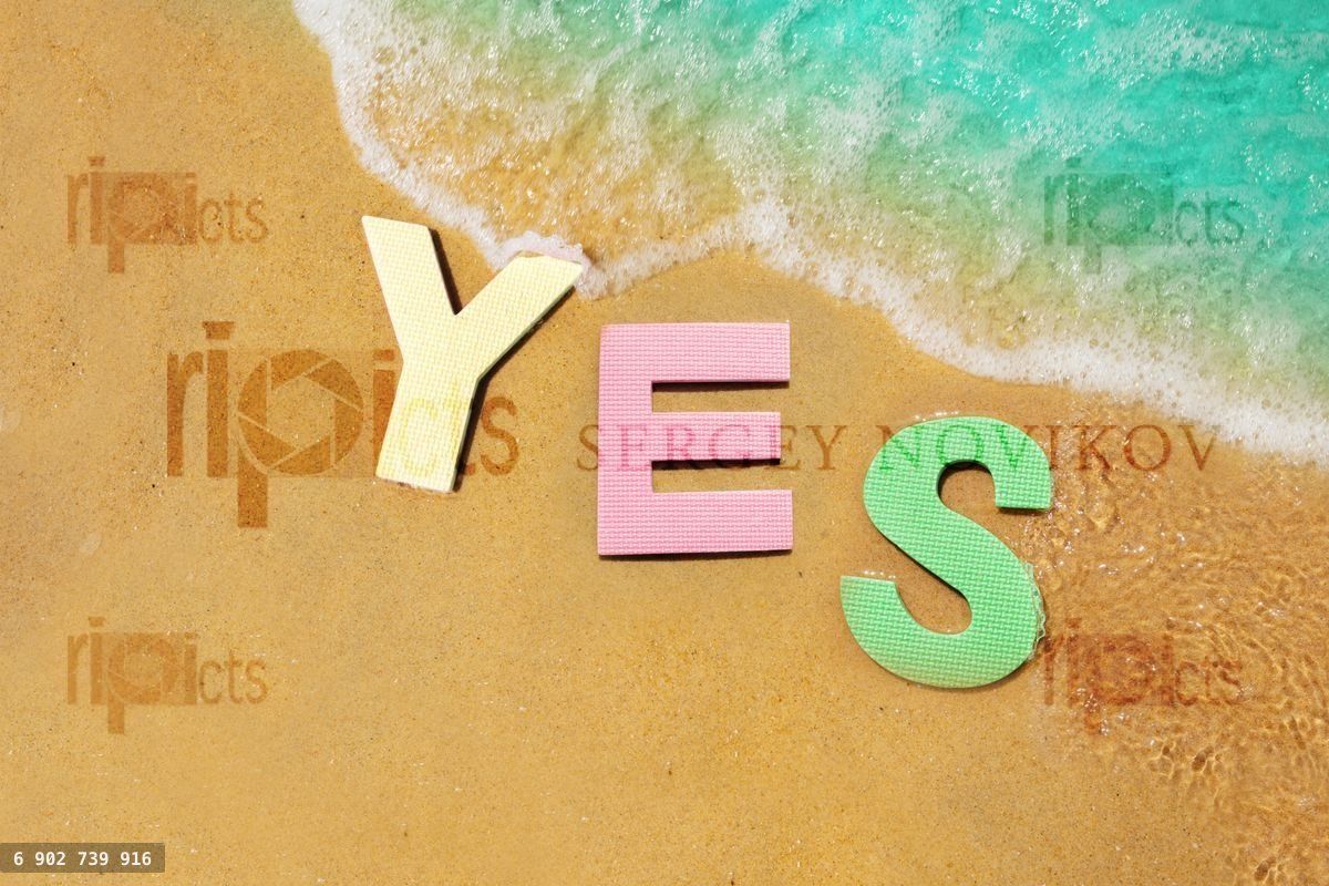 Yes sign floating in water near beach sand edge