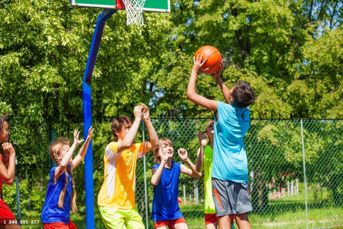 Group of teenagers play basketball on playground