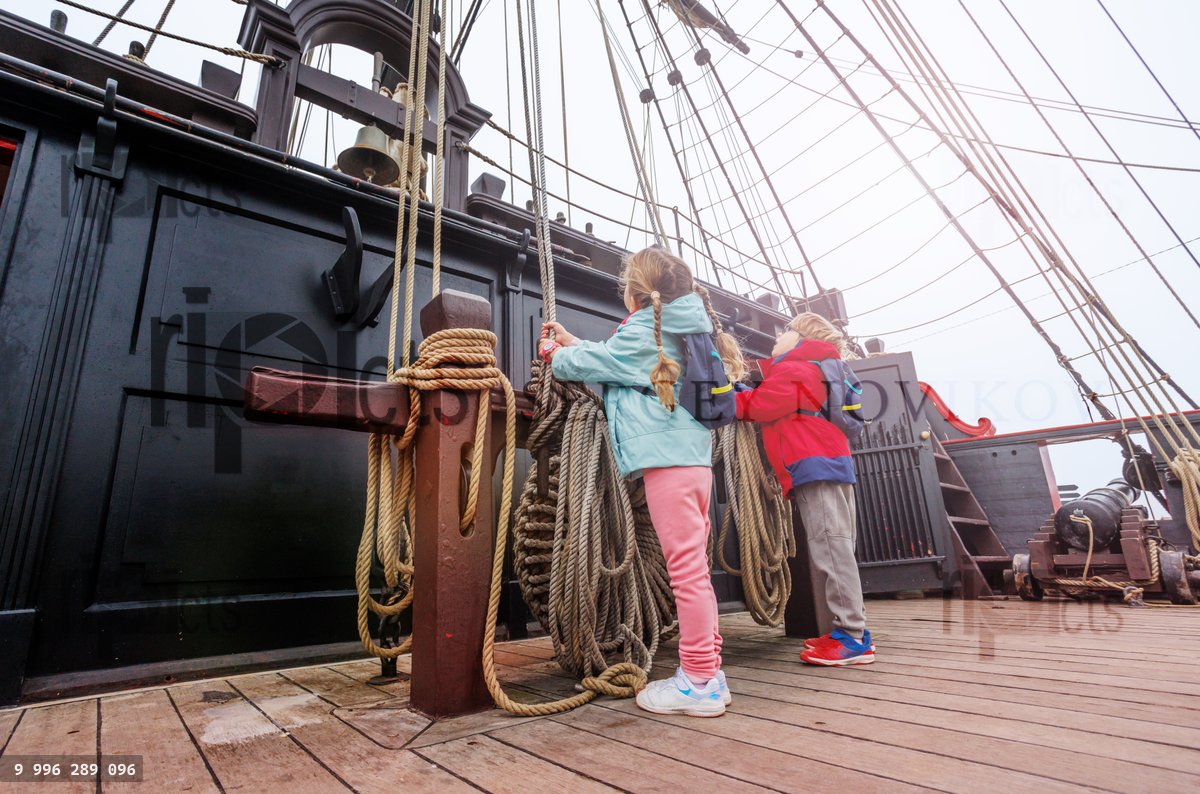 Des enfants énergiques tirent sur une corde sur le pont d'un vieux bateau pirate
