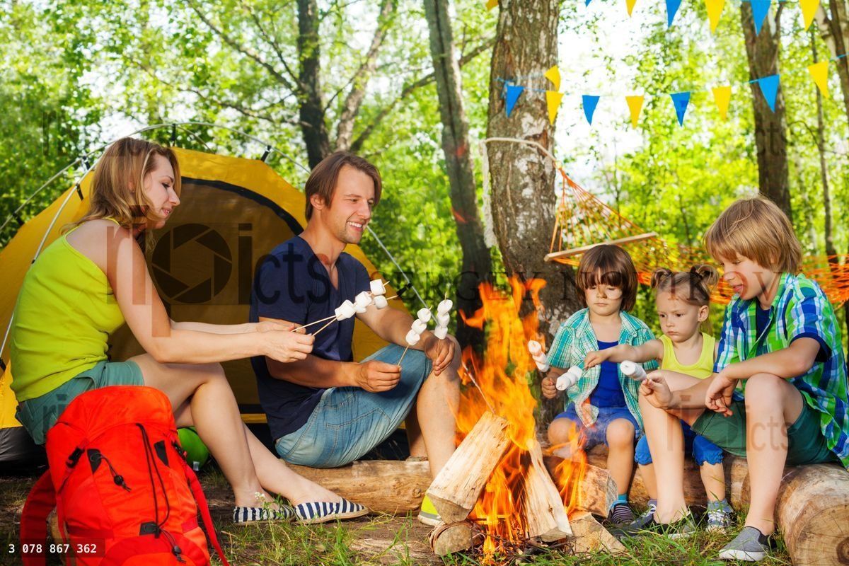 Happy family roasting marshmallow over the fire