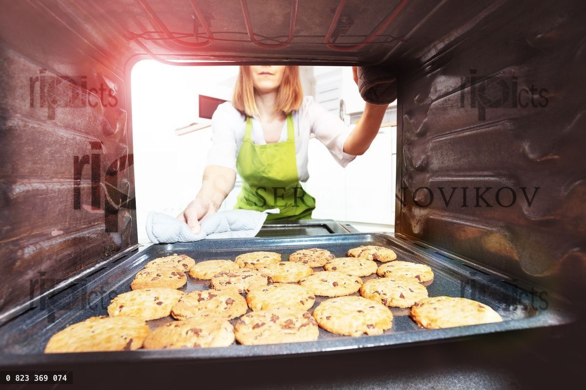Woman open the oven to check fresh baked cookies
