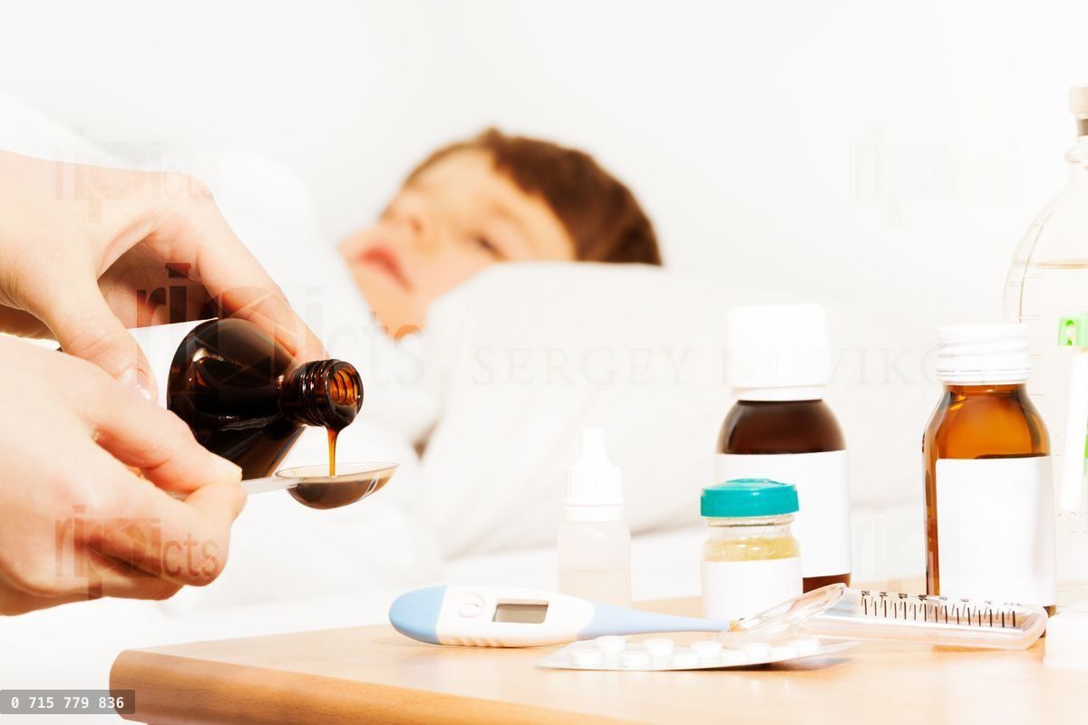 Woman's hands pouring antipyretic syrup for kid