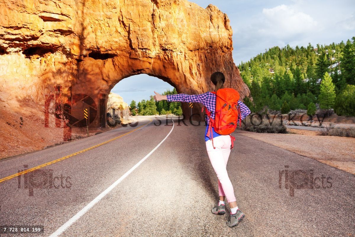 Girl hitch hiking on the road near Red canyon