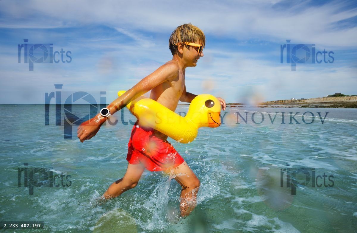 Fun at sea boy in sunglasses swim with inflatable duck