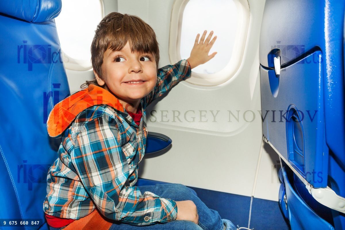 Enfant sur un avion touchant la fenêtre avec la main