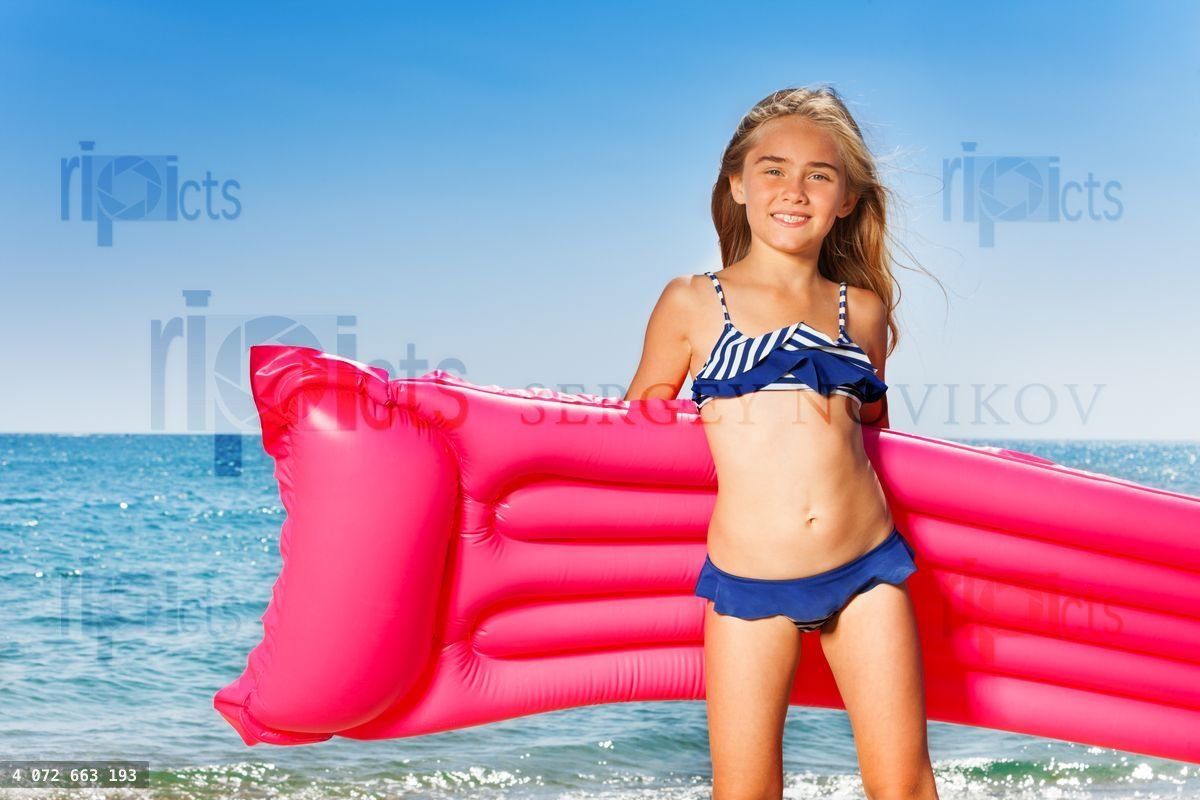 Young girl in bikini with pink inflatable mattress
