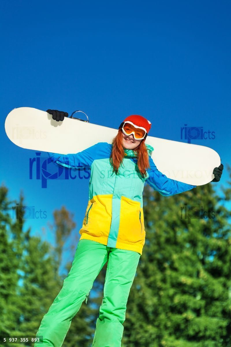 Woman in ski mask standing with snowboard