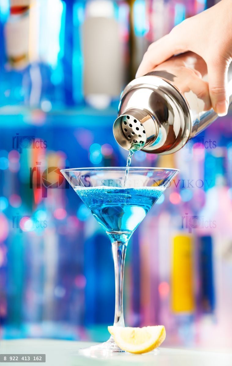 Hand of barman pouring liqueur to cocktail glass